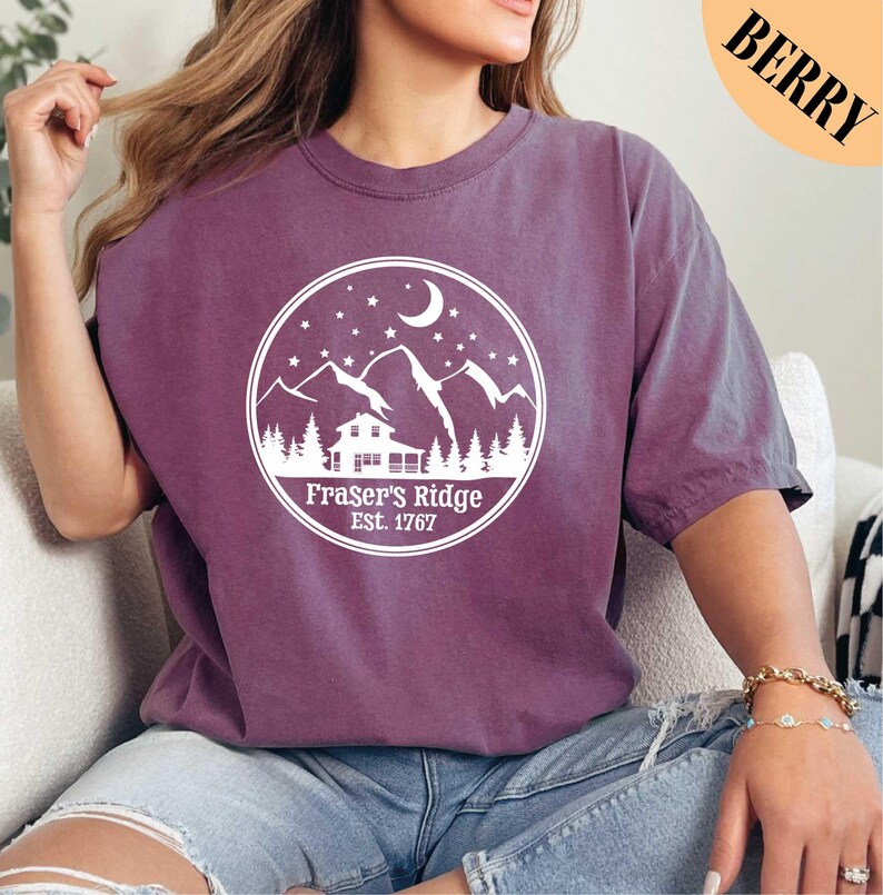 a woman sitting on a couch wearing a purple shirt