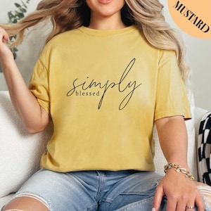 a woman sitting on a couch wearing a yellow shirt