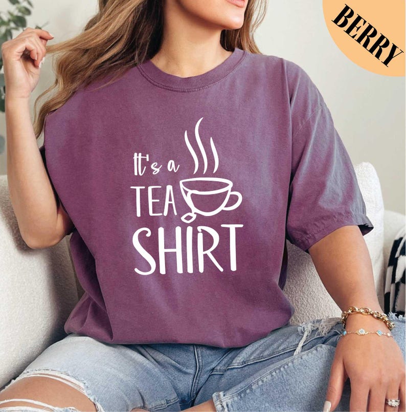 a woman wearing a t - shirt that says it's a tea shirt