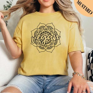 a woman sitting on a couch wearing a yellow shirt