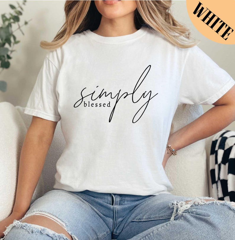 a woman sitting on a couch wearing a white simply t - shirt
