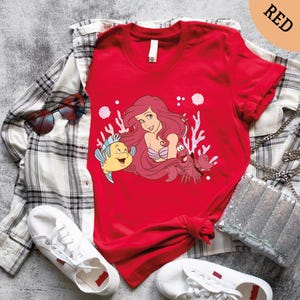 a red shirt with a little mermaid on it