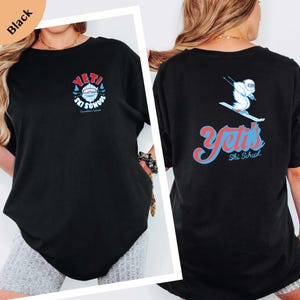 a woman wearing a black t-shirt with a graphic design on the back.