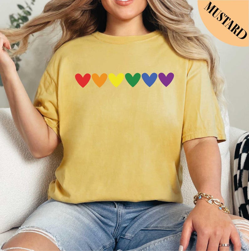 a woman sitting on a couch wearing a yellow shirt with hearts on it