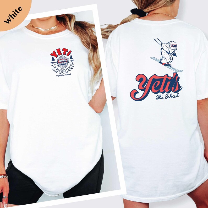 A white t-shirt with a graphic design on the front and back, featuring a snowboard and the text "YETI Ski School".