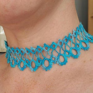 May include: A blue and turquoise crocheted choker necklace with a delicate, intricate design.