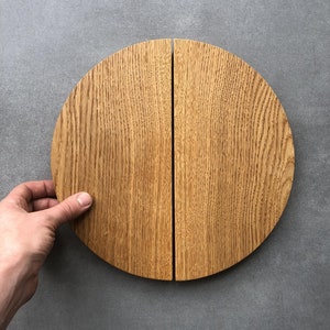 Może przedstawiać: Para drewnianych półokrągłych klamki do drzwi z naturalnym wykończeniem drewna.