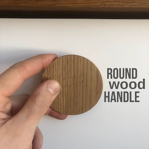 May include: A round wooden handle with a natural wood grain pattern. The handle is held against a white background. Text on the right reads "ROUND wood HANDLE".