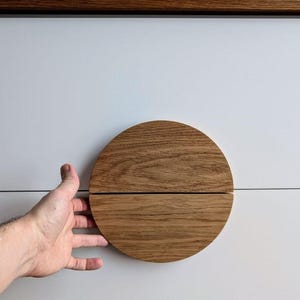 Könnte beinhalten: Ein runder, aus Holz gefertigter Schubladengriff. Der Griff besteht aus zwei Hälften, die ineinander passen.