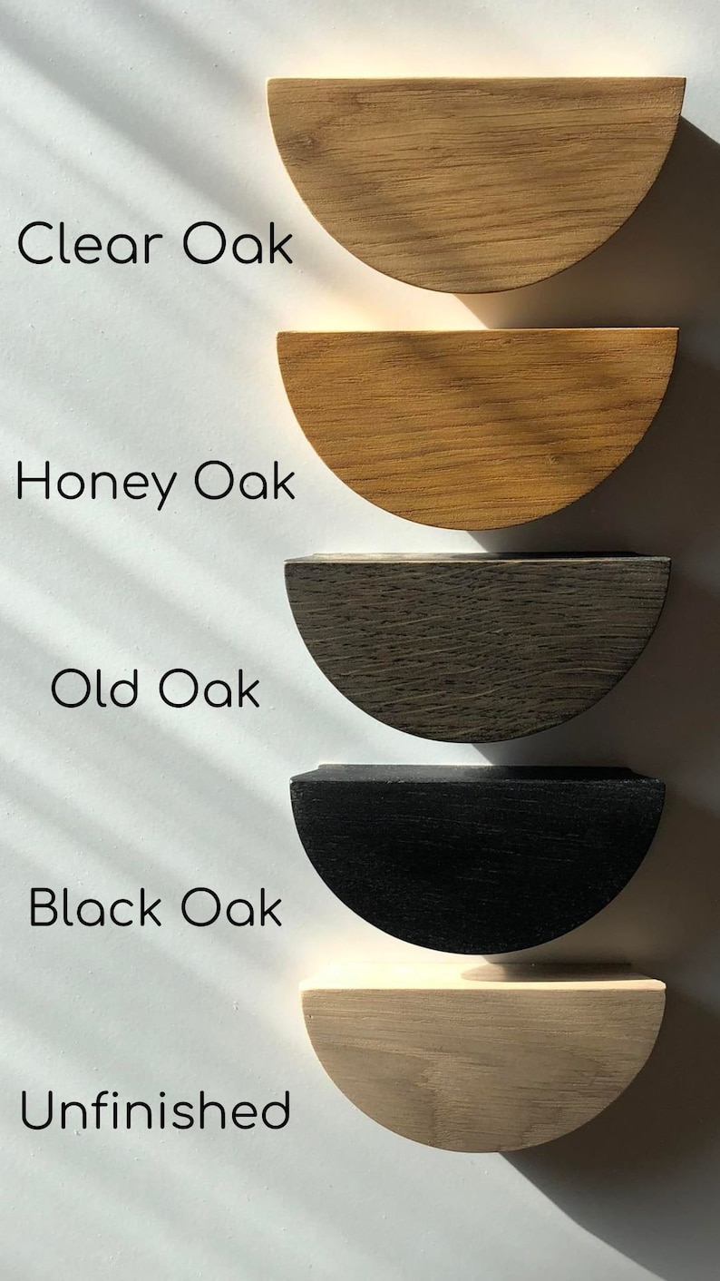 K&ouml;nnte beinhalten: F&uuml;nf halbkreisf&ouml;rmige Holzgriffe f&uuml;r Schubladen, vertikal angeordnet. Die Beschriftungen lauten Clear Oak, Honey Oak, Old Oak, Black Oak und Unfinished. Jeder Griff zeigt eine ausgepr&auml;gte Holzmaserung und ein Finish von hell bis dunkel.