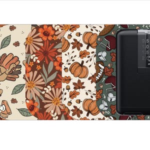 May include: A set of five different patterned phone skins featuring fall-themed designs. The designs include leaves, pumpkins, turkeys, and flowers. The skins are all in warm colors like orange, brown, and yellow. The skins are designed to fit a smartphone.