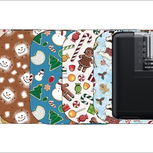 May include: Five different Christmas-themed designs for a medical device, featuring candy canes, gingerbread men, snowmen, cookies, and snowflakes. The device is black and has a clear plastic tube.