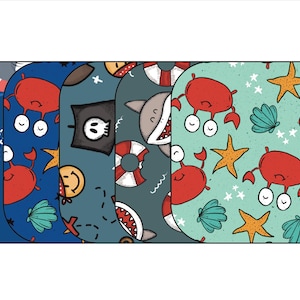 May include: Five different fabric swatches with nautical themes. The swatches feature repeating patterns of sharks, crabs, seashells, stars, life preservers, and pirate flags.