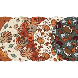 May include: Set of four round coasters featuring different Thanksgiving-themed patterns. One coaster has a green background with footballs, helmets, and leaves. Another has a cream background with a turkey, leaves, and acorns. A third has a cream background with orange pumpkins, leaves, and vines. The final coaster has a brown background with orange and red flowers and leaves.