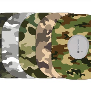 May include: Five different camouflage patterned adhesive patches for a Dexcom continuous glucose monitor. The patches are in black, gray, green, brown, and a green, brown, and tan camouflage pattern. The Dexcom logo is visible on the tan camouflage patch.