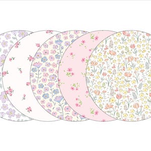 May include: Five round floral patterned placemats in shades of pink, yellow, and blue.