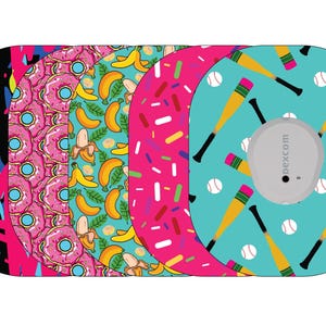 May include: A collection of Dexcom G6 sensor covers with various patterns. Designs include graffiti, pink donuts, bananas, sprinkles, and baseball bats with baseballs. The covers are oval-shaped with a circular sensor cutout.