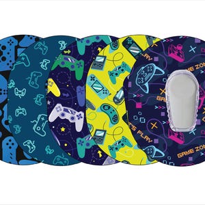 May include: Five round, colorful adhesive patches with a game controller pattern. The patches have a blue, yellow, and black background with a variety of colored game controllers and the text "Game Zone", "Let's Play", and "Game" on them.