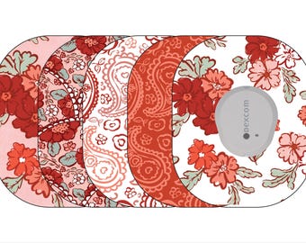 Könnte beinhalten: Vier verschiedene gemusterte Klebefolien für einen Dexcom G6 kontinuierlichen Blutzuckermessgerät. Die Folien zeigen Blumenmuster in Rot-, Rosa- und Weißtönen.