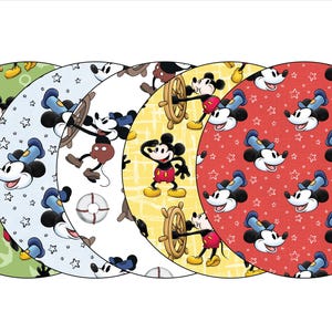 May include: Four round fabric placemats featuring a repeating pattern of Mickey Mouse in various poses. The placemats are green, blue, white, and red with different patterns.