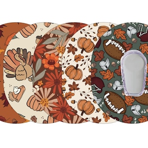 May include: Set of five round adhesive patches for a medical device. The patches feature different Thanksgiving-themed designs, including fall leaves, pumpkins, a turkey, flowers, and a football with a helmet and whistle.