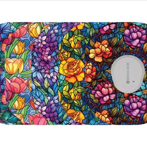 May include: A floral patterned medical device overlay featuring a stained glass design with red, yellow, purple, and blue flowers. The device has a gray circular component with the text "dexcom".