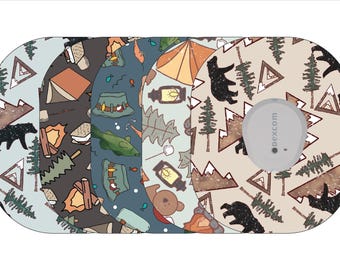 Könnte beinhalten: Drei verschiedene Designs für eine Dexcom G6 CGM-Geräteschutzfolie. Die Designs zeigen ein Camping-Thema mit Bären, Bergen, Bäumen und Zelten. Die Designs sind in Braun-, Blau- und Beigetönen gehalten.