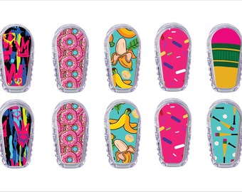 May include: Ten clear, plastic cases with colorful designs. The designs include graffiti, pink donuts, bananas, pink sprinkles, and baseball bats. The cases are likely for a small electronic device.