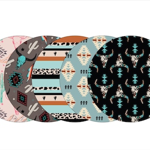 May include: Four round fabric coasters with different Southwestern-inspired patterns. The patterns include a pink and white skull with cacti, a gray and blue skull with cacti, a blue and brown striped pattern with animal print, and a black and blue skull pattern.