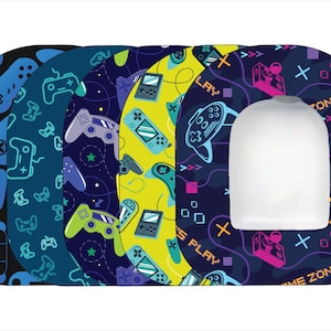 May include: Five different patterned toilet seat covers with a gamer theme. The patterns feature video game controllers, game cartridges, and the words "Let's Play" and "Game Zone".