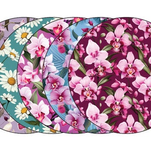 May include: Four round placemats with floral designs. The placemats feature pink orchids on a purple, teal, blue, and white background.