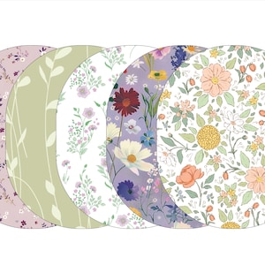 May include: Five round fabric placemats with different floral patterns. The placemats are in shades of green, purple, white, and pink.