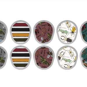 May include: A collection of ten decorative coasters with various insect-themed designs. The coasters feature illustrations of bees, ladybugs, and other insects, along with striped patterns. The color palette includes gray, burgundy, and white.