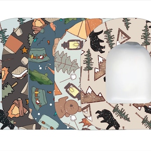 May include: Three different patterned fabric patches with a camping theme. The patches feature bears, mountains, trees, tents, and other camping-related imagery. The patches are in shades of brown, green, blue, and white.