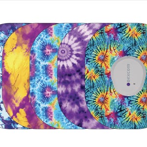 May include: Five different colorful tie-dye designs for a Dexcom G6 continuous glucose monitor. The designs are blue, yellow, purple, and a combination of blue, yellow, and purple.