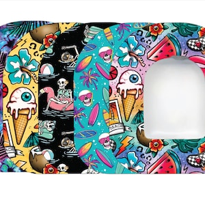 May include: A collection of patterned medical device covers with a variety of designs. The covers feature colorful illustrations of skulls, ice cream cones, surfboards, flamingos, and tropical elements. The covers have a white, oval-shaped cutout.