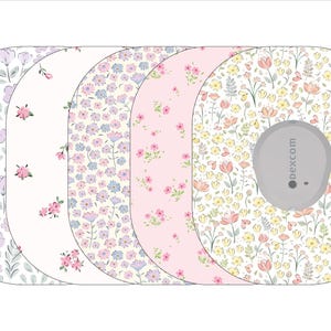 May include: Five different patterned adhesive sensor covers for a Dexcom continuous glucose monitor. The covers are oval shaped and feature a variety of floral patterns in shades of pink, purple, and yellow.