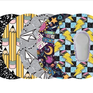 May include: A collection of five circular adhesive patches with various school-themed designs. The designs include a composition notebook pattern, pencils, paper airplanes, a space theme, and lightning bolt pencils. One patch has a clear, oval-shaped opening.
