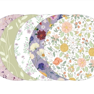 May include: Five round floral patterned placemats in shades of green, purple, white, and pink. The placemats are arranged in a circle with the largest placemat in the center.