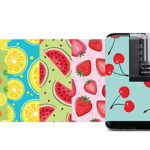 May include: A black and clear vape device with a variety of colorful fruit-themed designs. The designs include watermelon, lemons, strawberries, and cherries.
