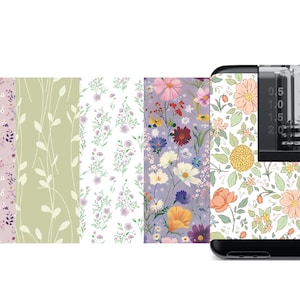 May include: A black and clear medical device with a floral patterned skin. The device has a clear reservoir with a scale marked in 0.5 ml increments up to 2.5 ml. The floral pattern features a variety of flowers in shades of pink, yellow, and orange.
