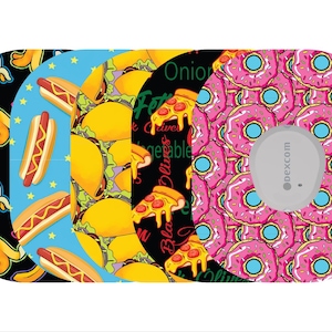 May include: A collection of patterned medical device covers. Designs include bananas on black, hot dogs on blue, tacos, pizza, and pink donuts. A gray device is centered on the donut design.
