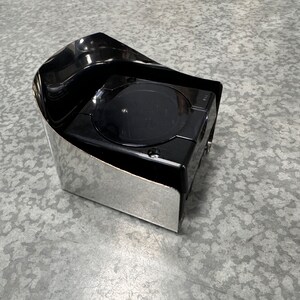 May include: A black and silver automotive accessory with a rounded, curved top and a square base.