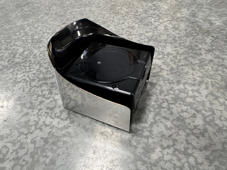 May include: A black and silver automotive accessory with a rounded, curved top and a square base.