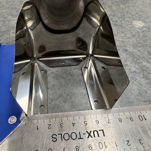 May include: A close-up of a stainless steel metal sheet with multiple holes and a ruler measuring 10 inches. The ruler is labeled "LUX-TOOLS".