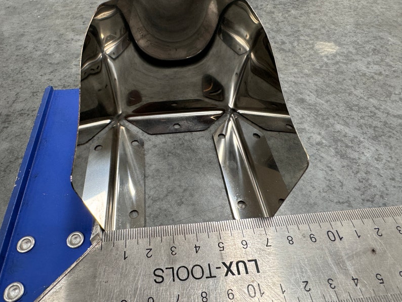 May include: A close-up of a stainless steel metal sheet with multiple holes and a ruler measuring 10 inches. The ruler is labeled "LUX-TOOLS".