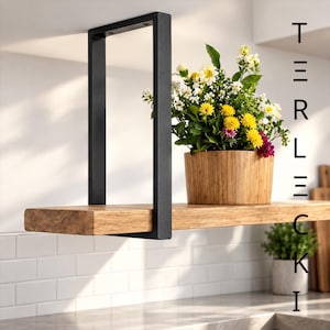Könnte beinhalten: Ein schwebendes Regal mit einer dicken Naturholzplatte, die von einer mattschwarzen U-förmigen Metallhalterung getragen wird. Ein Bambusübertopf mit gelben und weißen Blumen steht auf dem Regal. Der Text TERLECKI ist rechts zu sehen.