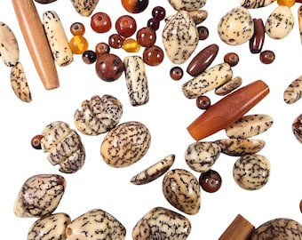 May include: A collection of various beads in shades of brown, beige, and amber, scattered against a white background. The beads vary in shape, including round, oval, and cylindrical, with speckled and solid patterns. Some beads have a glossy finish.