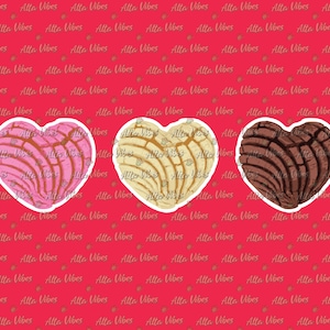 May include: Three heart-shaped pastries, known as conchas, in pink, white, and brown. The pastries have a distinctive shell-like design.