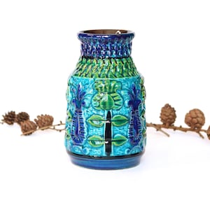 May include: A blue and green ceramic vase with a geometric pattern. The vase has a wide mouth and a narrow base.